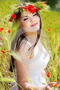 Portrait of an attractive beautiful girl in a poppy field