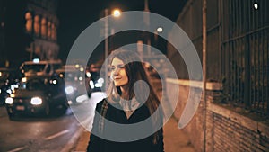 Portrait of attractive beautiful woman walking in the city centre near the Colosseum in Rome, Italy late at night.