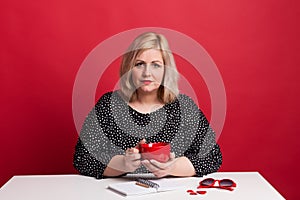 Portrait of an attractive overweight woman in studio on a red background. photo