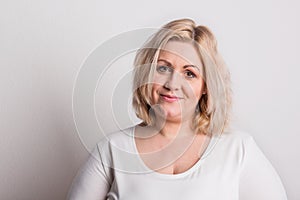 Portrait of an attractive overweight woman in studio on a white background. photo