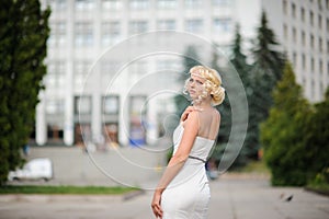 Portrait of attractive blonde girl with long hair posing in a park. Summer picture