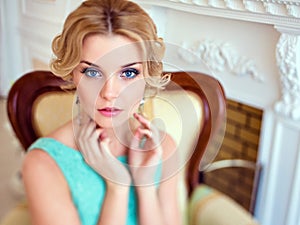 Portrait of an attractive blue-eyed blonde in a blue dress, close up