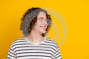 Portrait of attractive brunet curls teenage guy looking empty space smiling good emotions memories isolated on yellow