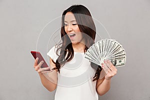 Portrait of attractive brunette female 20s winning lots of money