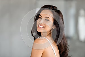 Portrait of attractive brunette long-haired woman smiling at camera