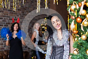 Portrait of attractive brunette woman on New Year`s party near decotated Christmas tree