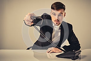 Portrait of attractive businessman holding telephone in his hand