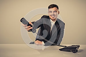 Portrait of attractive businessman holding telephone in his hand