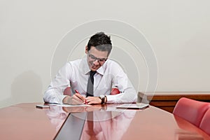 Portrait Of Attractive Businessman Reading Paper In Office