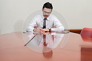 Portrait Of Attractive Businessman Reading Paper In Office