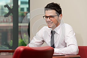 Portrait Of Attractive Businessman Reading Paper In Office