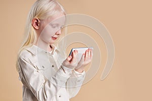 Portrait of attractive caucasian albino girl with smartphone