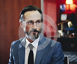 Portrait of attractive caucasian bearded aged guy at workplace