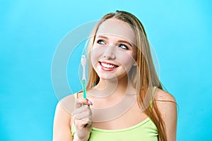 Portrait of attractive caucasian smiling woman  on white studio shot brushing her teeth