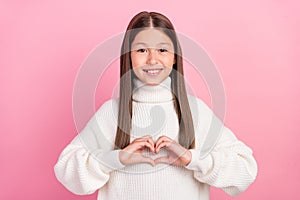 Portrait of attractive cheerful amorous girl showing heart symbol amour date isolated over pink pastel color background