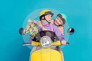 Portrait of attractive cheerful couple riding bike embracing pastime isolated over bright blue color background