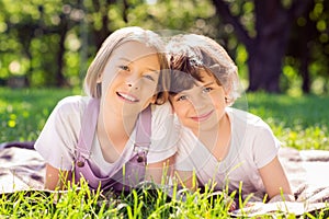 Portrait of attractive cheerful family siblings lying on grass veil duvel bonding spending time on fresh air sunny day