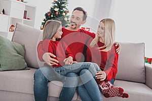 Portrait of attractive cheerful family wife husband sitting on sofa spending festal vacation newyear at light home