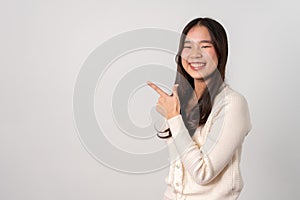 Portrait of attractive cheerful girl demonstrating and pointing finger to the side empty space isolated white background, showing