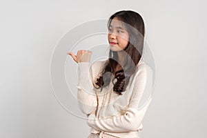 Portrait of attractive cheerful girl demonstrating and pointing finger to the side empty space  white background, showing