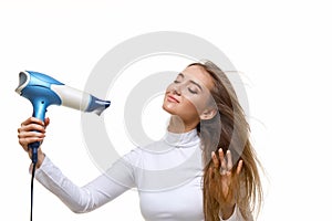 Portrait of attractive cheerful girl drying long hair