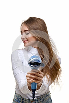 Portrait of attractive cheerful girl drying long hair