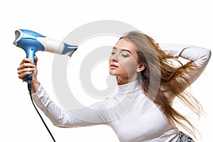 Portrait of attractive cheerful girl drying long hair