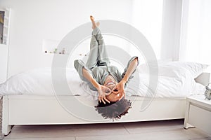 Portrait of attractive cheerful girl lying in bed having fun showing ok-sign like glasses fooling at light home house