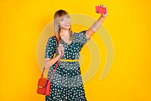 Portrait of attractive cheerful girl taking making selfie posing trip journey isolated over bright yellow color