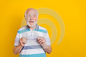 Portrait of attractive cheerful grey haired curious man creating solution copy space isolated over bright yellow color