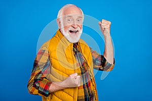 Portrait of attractive cheerful grey-haired man rejoicing having fun great success isolated over bright blue color