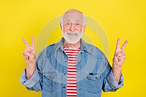 Portrait of attractive cheerful grey-haired man showing double v-sign isolated over shine yellow color background