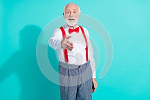 Portrait of attractive cheerful grey-haired mister giving you hand greetings isolated over bright teal turquoise color