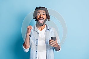 Portrait of attractive cheerful lucky guy using gadget browse media like follow having fun isolated over bright blue