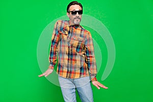 Portrait of attractive cheerful man fooling dancing having fun moving rest isolated over bright green color background