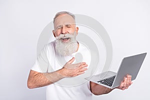 Portrait of attractive cheerful man using laptop reading joke funny laughing  over light grey color background