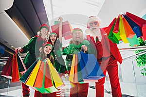 Portrait of attractive cheerful people fairy elfs buying gifts having fun newyear day at shopping mall indoors