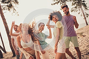 Portrait of attractive cheerful people group spending day dancing chill out having fun at beach outdoors