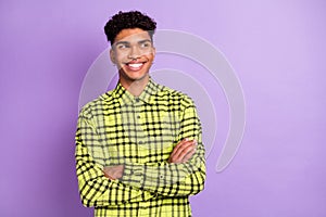 Portrait of attractive cheerful wavy-haired guy wear checked shirt folded arms copy space isolated over violet purple