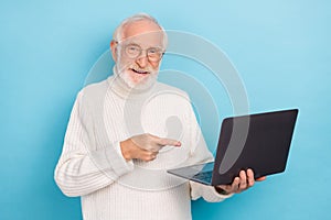 Portrait of attractive cheery skilled grey-haired man using demonstrating laptop isolated over bright blue color