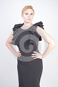 Portrait of attractive chubby young woman in tight black dress