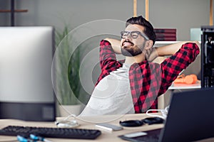 Portrait of attractive clever skilled cheerful guy resting in chair solving tech issues task project at work place