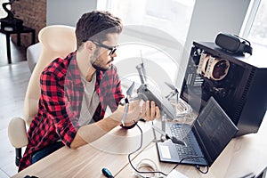 Portrait of attractive clever smart focused guy fixing drone bug software programming code security data at work place