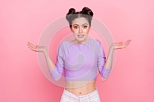 Portrait of attractive confused girl shrugging shoulders dont know isolated over pink pastel color background