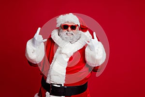 Portrait of attractive crazy Santa showing horn symbol having fun newyear occasion isolated over bright red color