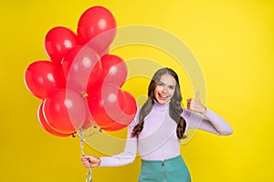 Portrait of attractive curly hairstyle lady hold red balls show thumb up approve isolated on yellow color background