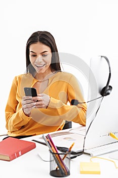 Portrait of attractive customer supporter woman using smartphone while working in call center