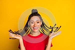 Portrait of attractive cute cheeeful girl throwing modern coiffure hair having fun isolated on bright yellow color