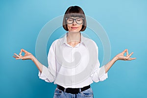 Portrait of attractive dreamy calm girl meditating hobby free time isolated over vibrant blue color background