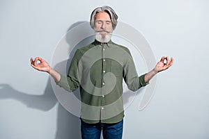 Portrait of attractive dreamy calm grey-haired man meditating free time isolated over gray pastel color background